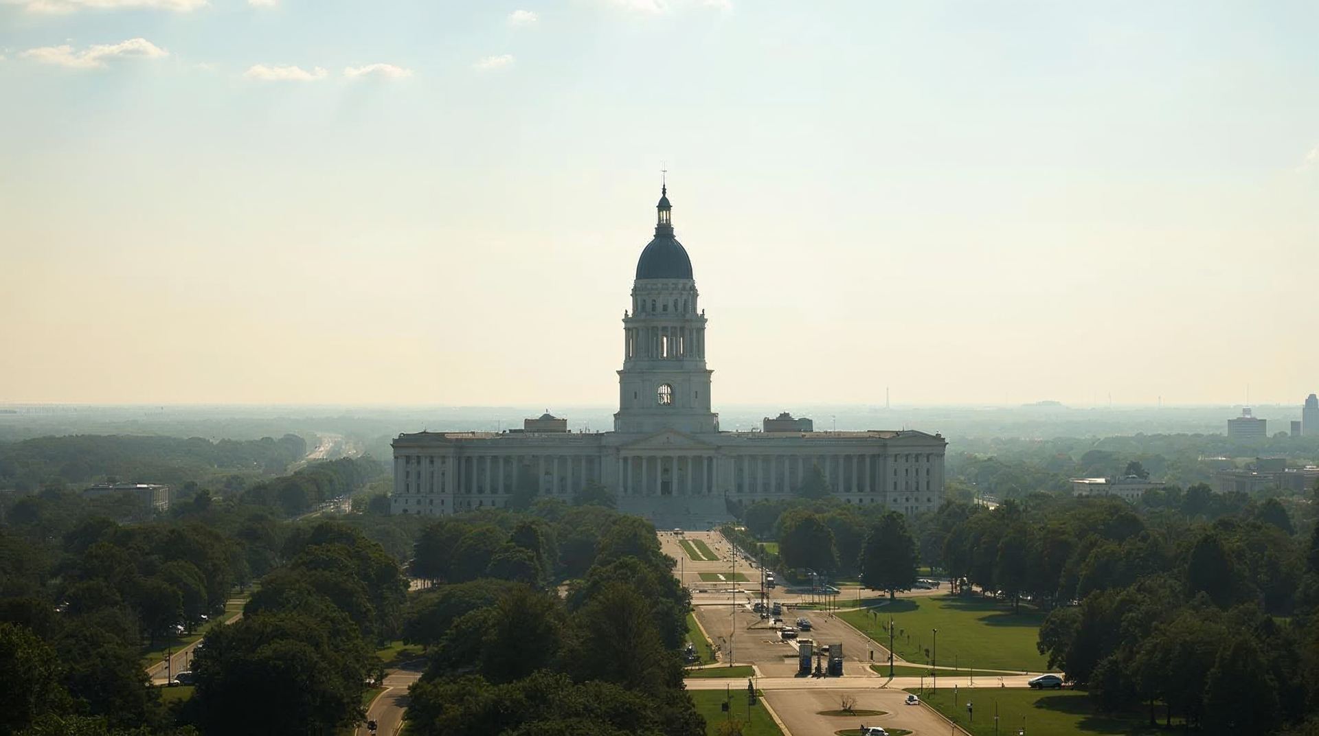 The Nebraska State Capitol tower in Lincoln above green trees on a clear morning