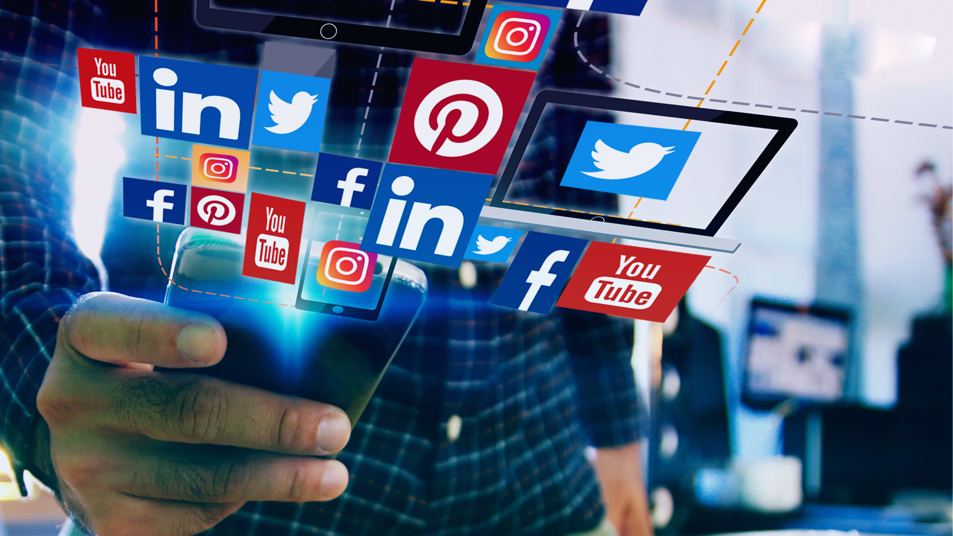 man holding a phone with a design of different social media icons floating in the air from the phone