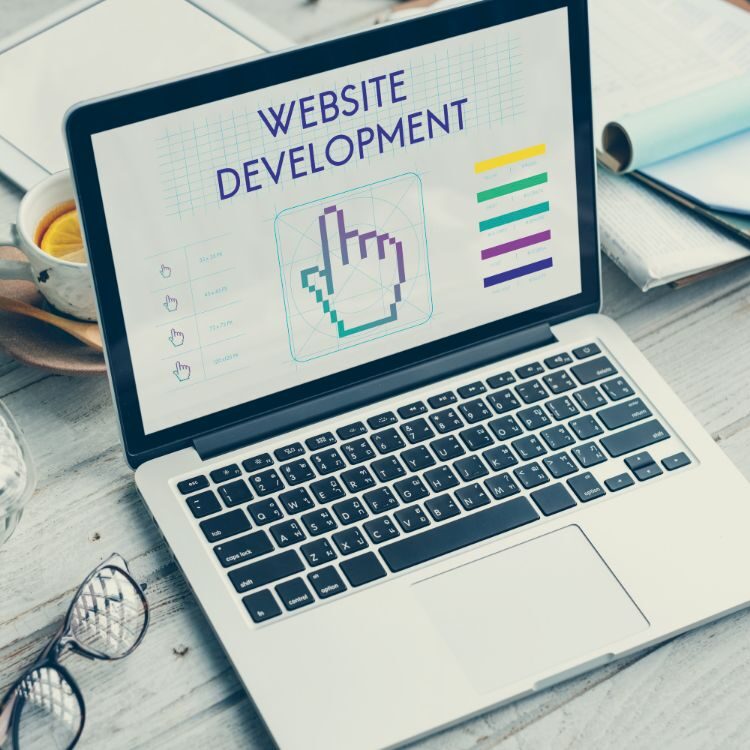 macbook laptop with "website development" and a large cursor hand centered beneath it