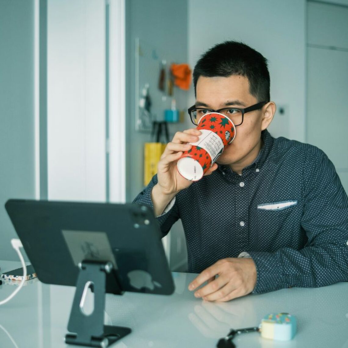 man drinking coffee at his computer desk while he's fixing the Error Establishing a Database Connection in WordPress
