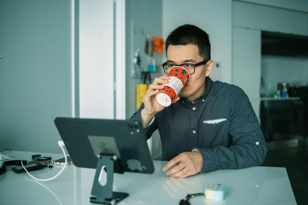 man drinking coffee at his computer desk while he's fixing the Error Establishing a Database Connection in WordPress